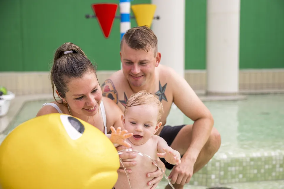 Familie i badeland p� feriecenter � pakkeliste med badet�j, h�ndkl�der og k�kken til feriehus